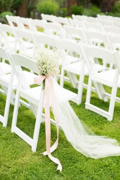 white folding chairs with pink ribbon and baby's breath flowers tied to the back