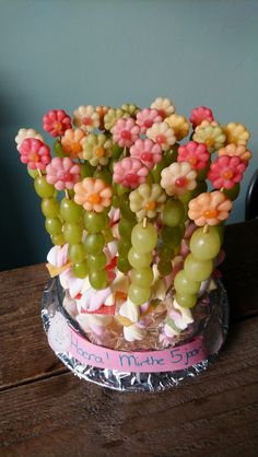 a vase filled with lots of different types of candies on top of a wooden table