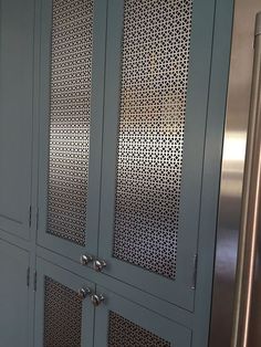 a metallic refrigerator freezer sitting inside of a kitchen next to a metal wall mounted oven