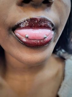 a close up of a woman's lips with piercings