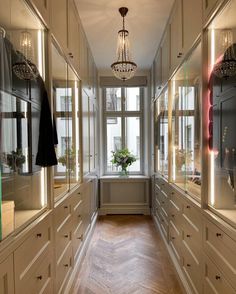 a long hallway with lots of cabinets and a chandelier hanging from the ceiling