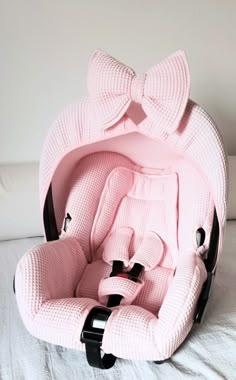 a baby seat with a pink bow on it