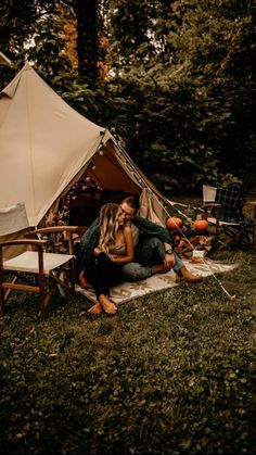 two people sitting in front of a tent