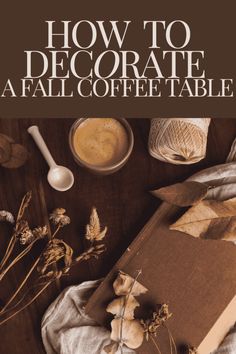 an open book sitting on top of a wooden table next to flowers and coffee mug