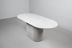 a white table sitting in the middle of an empty room with no one around it