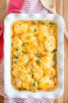 a casserole dish with bananas and parsley in it on a wooden table