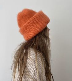 a woman with long hair wearing an orange hat