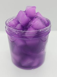 a plastic container filled with purple ice cubes on top of a white countertop