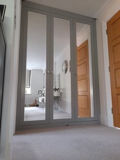 an empty room with mirrored doors and a clock on the wall