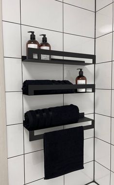 black towels and soaps are on shelves in the bathroom