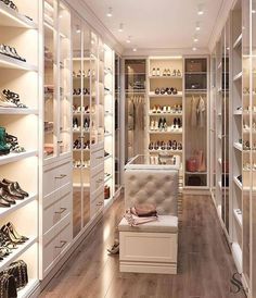 a walk in closet filled with lots of white shelves and shoes on top of them