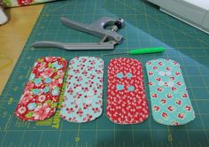 the scissors are laying next to four different patterns on the cutting board, along with some sewing supplies