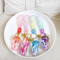 four plastic bottles with candy in them are on a plate next to a white pillow