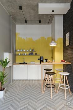 a kitchen with yellow painted walls and stools