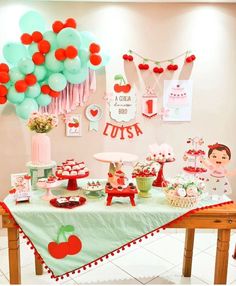 a table topped with lots of desserts and balloons