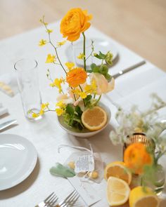 the table is set with flowers and lemons