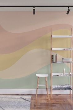 a living room with a book shelf and wall mural in pastel colors on the walls