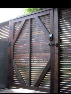 an image of a wooden gate with shutters on the sides and side doors open