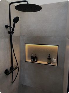 the shower head is mounted on the wall next to the shelf with bottles and soaps