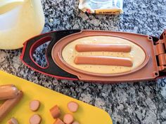 two hot dogs in a pan with mustard and ketchup on the counter next to other ingredients