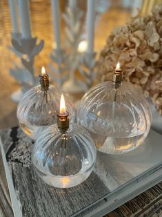 two clear glass candle holders sitting on top of a table