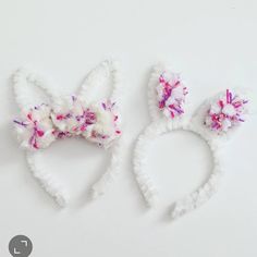 two white bunny ears with pink flowers on them