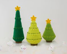 three crocheted christmas trees sitting next to each other