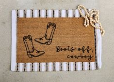 a door mat with two boots on it that says boots off cowboy written in black ink