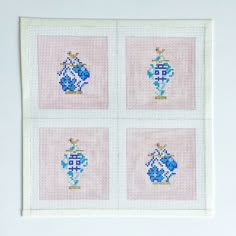 four cross - stitch squares with blue vases on them