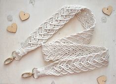 two white lanyards with hearts on the table next to them, one is tied up and the other has been made out of yarn