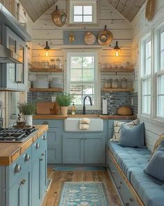 a kitchen with blue cabinets and wood flooring is shown in this small cabin style home