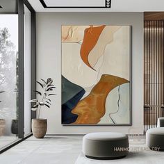 an abstract painting hangs on the wall in a modern living room with large glass doors