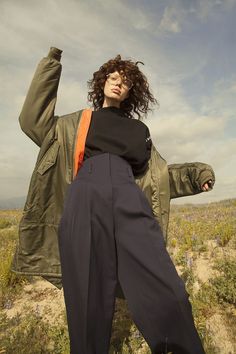 a woman standing in the middle of a field