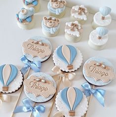 a table topped with cupcakes covered in frosting and decorated like hot air balloons