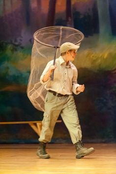 a man with a net on his head is walking while holding an umbrella in one hand