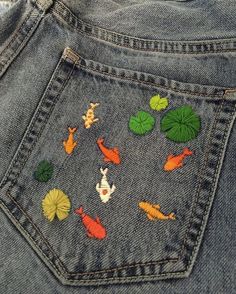 the back pocket of a pair of jeans with fish and lily pads on them