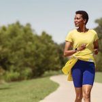 a woman running down a path in the park