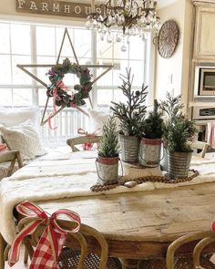 a dining room table with potted plants on it and a star hanging from the ceiling