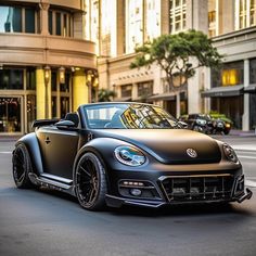 a black and gold convertible car driving down the street