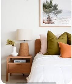 a bedroom with a bed, nightstand and palm tree on the wall in front of it