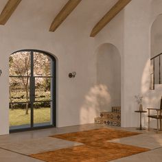 an open door leading into a large room with a brown area rug on the floor