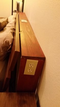 a bed sitting next to a wooden night stand