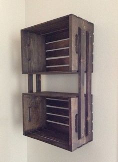 two wooden crates are attached to the wall and have handles on each side that hold drawers