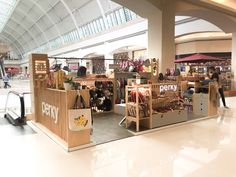 the inside of a mall with people shopping and looking at items on display in it