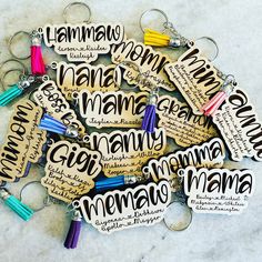 many wooden key chains with writing on them and tassels attached to each other