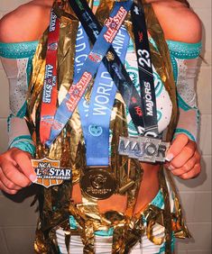 a woman in a costume holding up her medal and wearing it as a ribbon around her neck