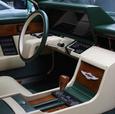 the interior of a car with wood trim and green leather seats, steering wheel and dash board