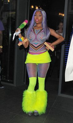 a woman dressed in neon clothing holding two skateboards