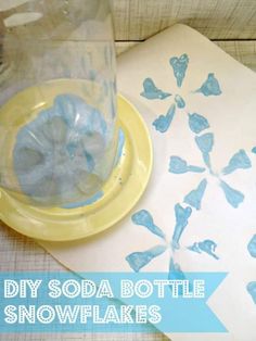 a glass bottle sitting on top of a table next to a paper with blue snowflakes in it