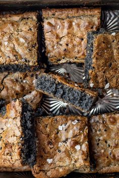 a tray filled with brownies covered in black and white toppings on top of a wooden table